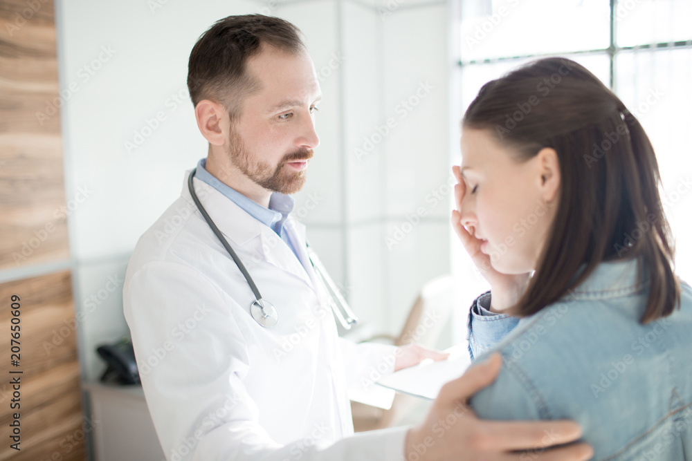 Young clinician comforting upset patient after telling her diagnosis Young clinician comforting upset patient after telling her diagnosis