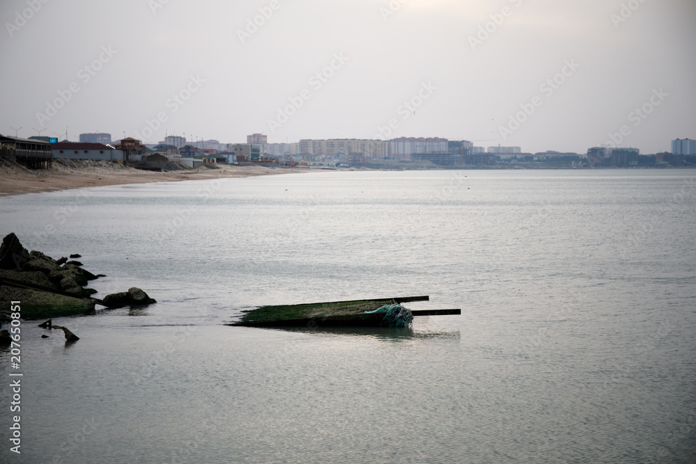 Obraz premium Beautiful landscape of abandoned house on rocky seashore at sunset time. Cloudy weather. Caspian Sea, Azerbaijan