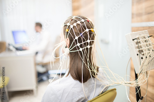 Back view of patient with eeg equipment on her head during brain activity clinical test photo