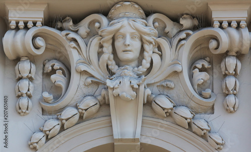 Architectural detail with a mascaron of a young woman set on top of a column on the facade of an old building, Zagreb, Croatia 