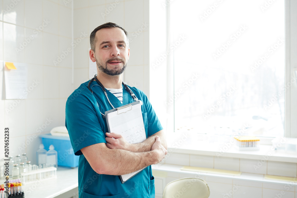 Young successful doctor with medical document looking at camera in his own clinics Young successful doctor with medical document looking at camera in his own clinics
