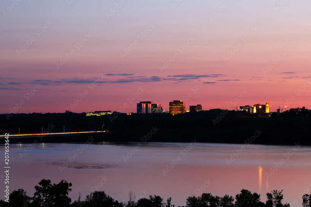 Fototapeta premium Zachód słońca nad Bloomington, Minnesota z rzeką Mississippi na pierwszym planie.