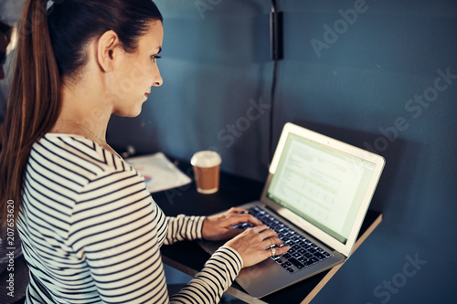 Young designer working on a laptop at an office table