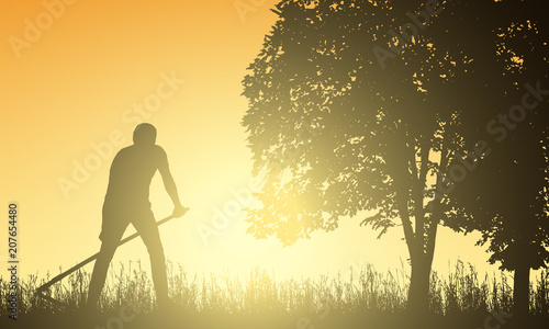 Man mowing grass with a scythe under the tree at sunrise