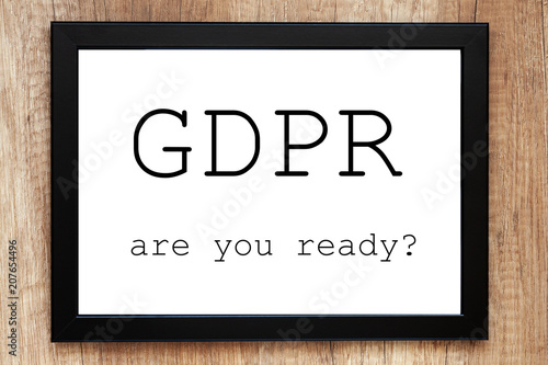 Top view of a desk with a black frame with the words "GDPR are you ready?"