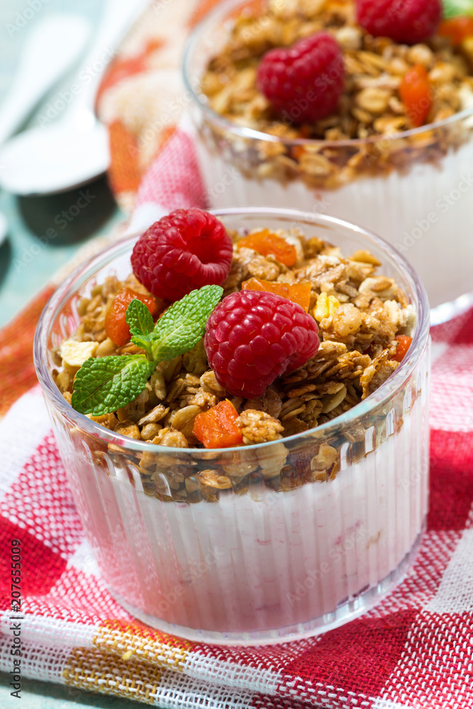 dessert with granola, raspberry and fruit yoghurt, vertical dessert with granola, raspberry and fruit yoghurt, vertical