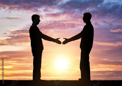 Silhouette two men intend to shake hands.