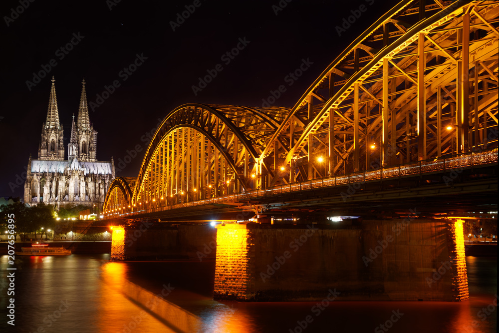 Fototapeta premium The view over the river Rhine with the Hohenzollern Bridge and the Cathedral at night is one of the most impressive views in Cologne, Germany 