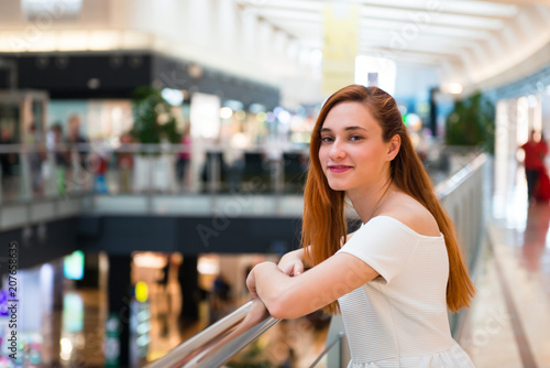 Young redhead pretty girl in a shopping center