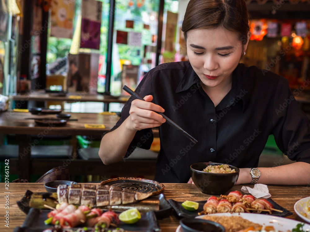 Beautiful asian woman eating sashimi, Woman enjoy eat japan food in Tradition japan restaurant.