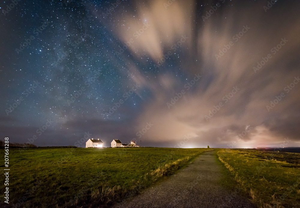 Fototapeta premium Milky way behind clouds over farm Skandinavia