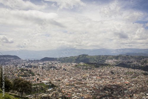 Flag of the Republic of Ecuador, on a sunny day with the city of Quito in the background. © tyto08