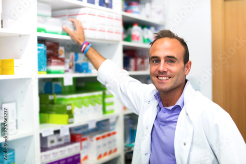 Happy adult man pharmacist in pharmacy