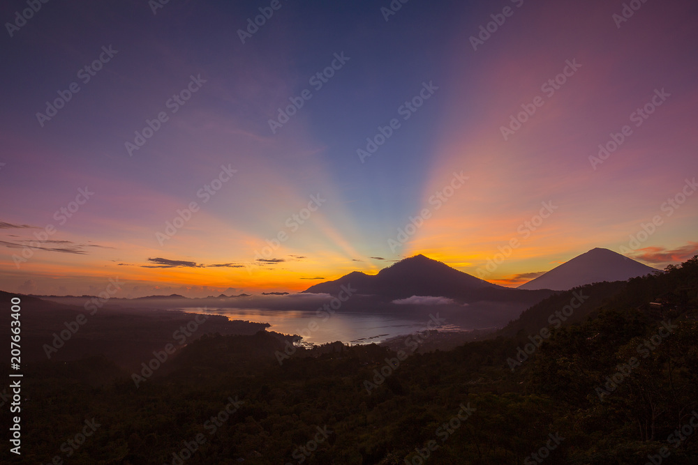 Obraz premium Scenic sunrise and mist at Agung volcano, Kintamani, Bali, Indonesia. Sunrise view of Agung volcano, nature landscape