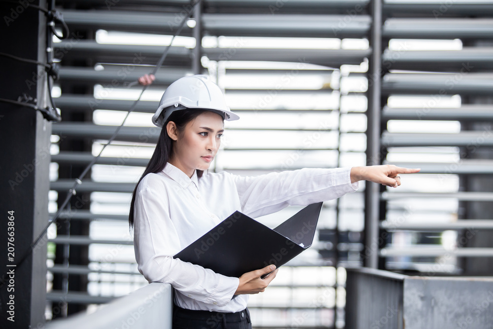 Female engineer inspecting construction work in hand holding clipboard with document. Female engineer inspecting construction work in hand holding clipboard with document.