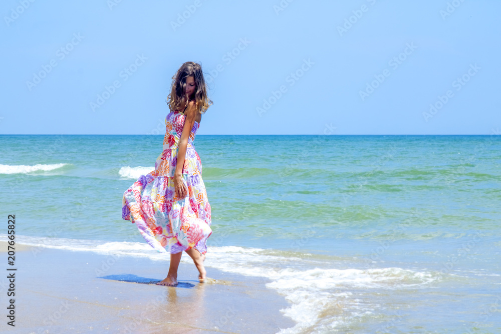 Portrait of beautiful, brunette young woman againstof blue ocean. Freedom, happiness and holiday concept.