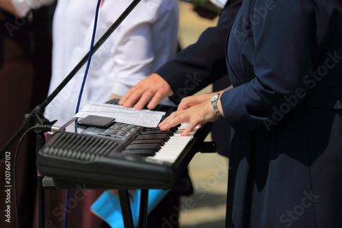 Kobieta w stroju zakonnicy gra na organach elektronicznych.