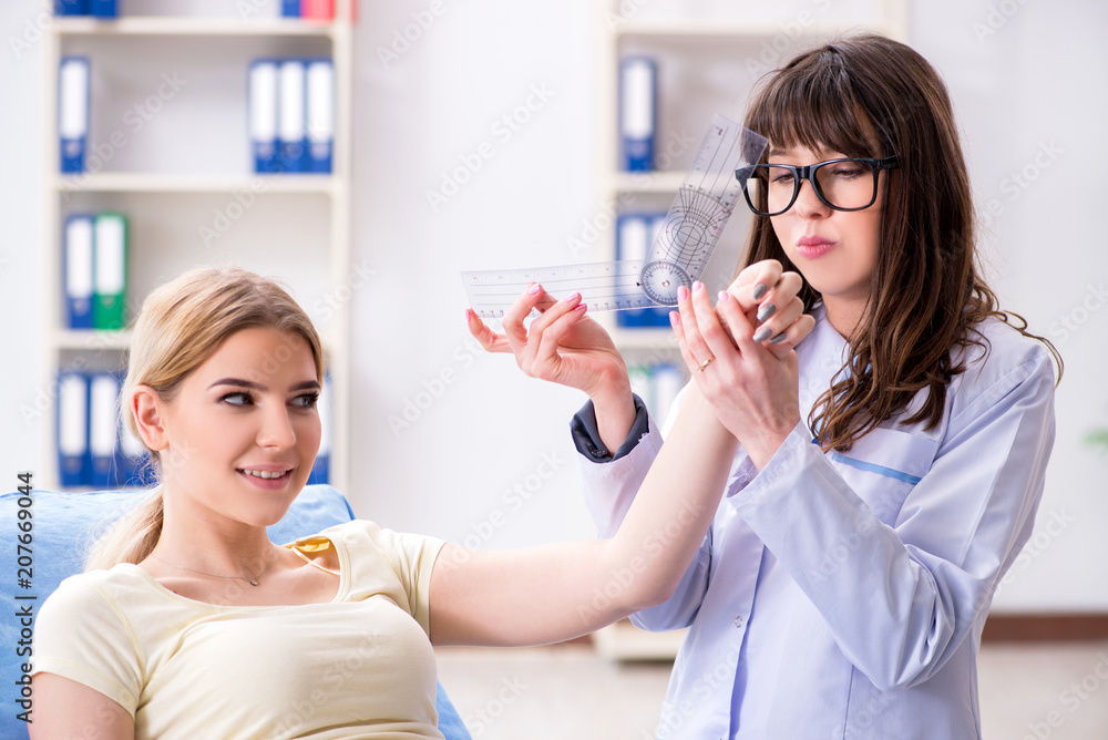 Doctor checking joint flexibility with goniometer Doctor checking joint flexibility with goniometer