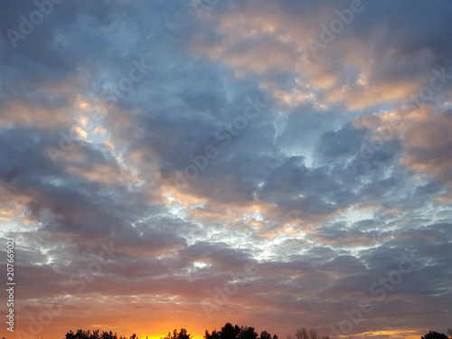 Fiery orange sunset  colorful and speckled  clouds. © Lumppini