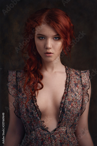 Dramatic retro portrait of a young beautiful dreamy redhead woman. Soft vintage toning. photo