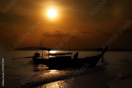 traditional thai longtail boat silhouette at sunset