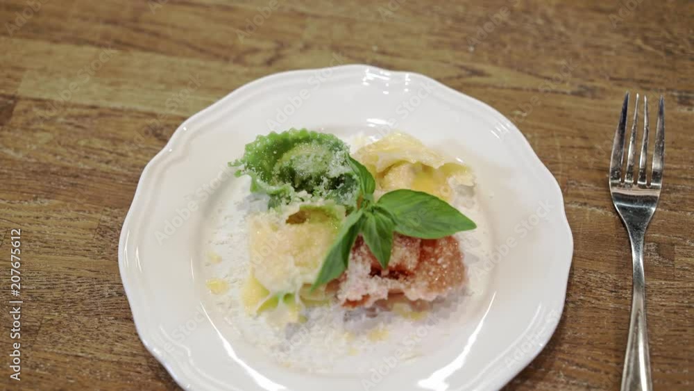 Top view of yellow, red and green tortellini on a plate ready to be served. Slider real time medium shot Top view of yellow, red and green tortellini on a plate ready to be served. Slider real time medium shot