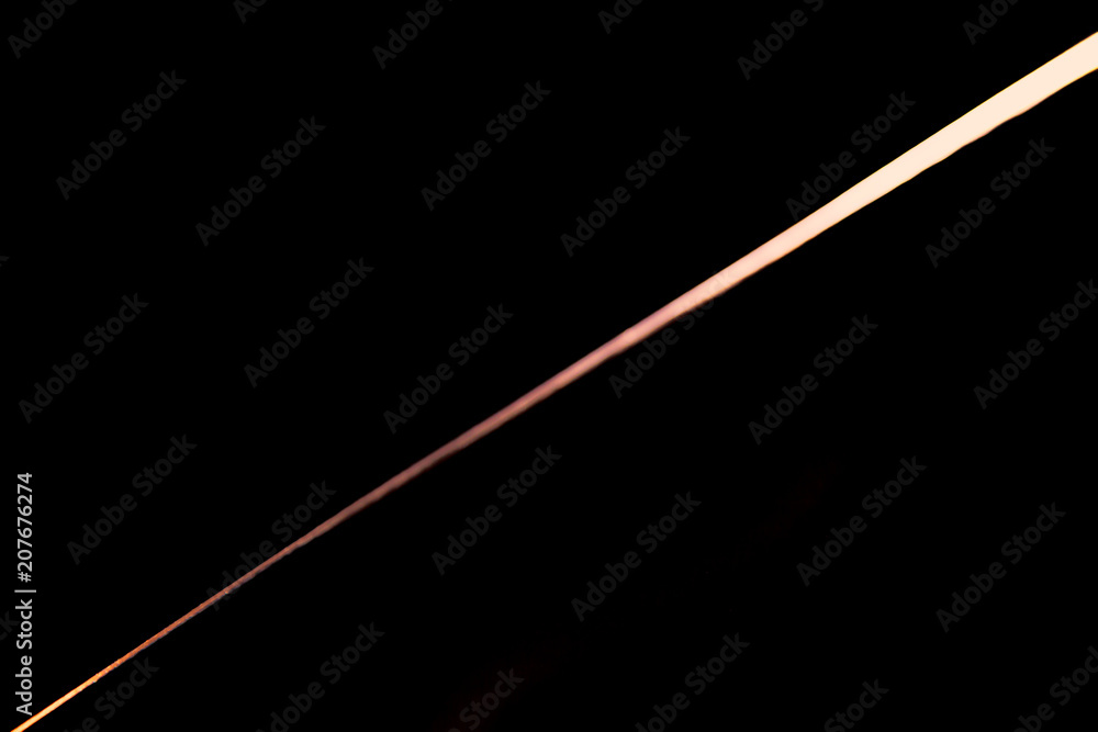 Narrow beam of light on the blade of a steel knife on a black abstract background Narrow beam of light on the blade of a steel knife on a black abstract background