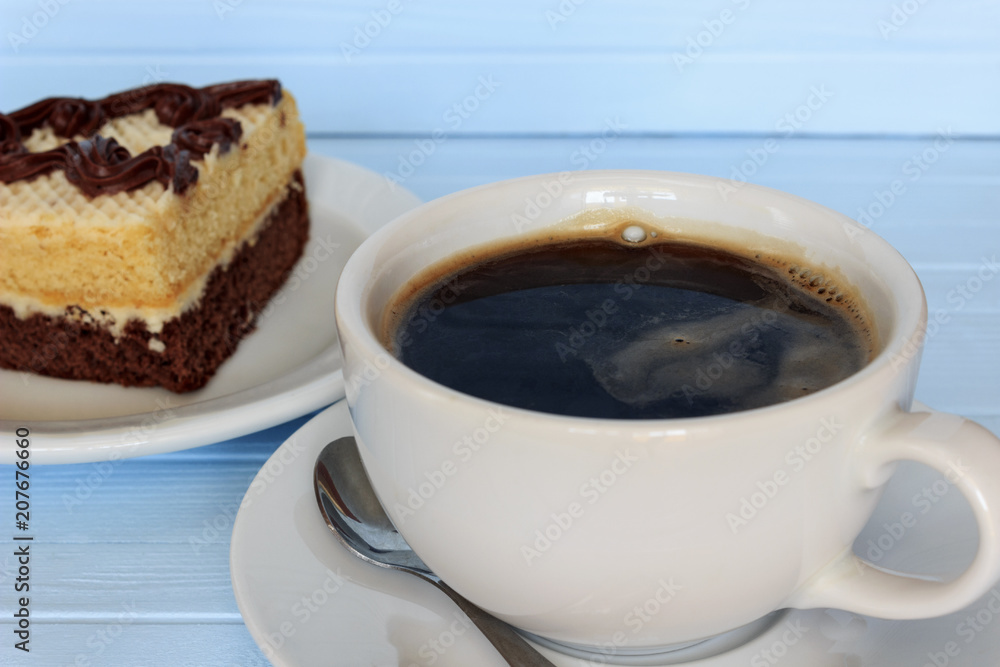 a piece of cake in a plate with a cup of coffee on a blue tree background a piece of cake in a plate with a cup of coffee on a blue tree background