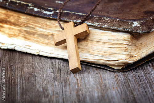 Ancient holy book of a wooden cross on a cord.