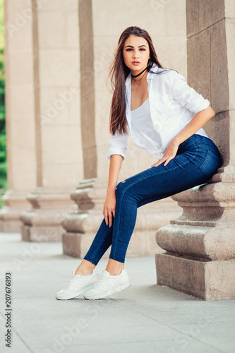 young stylish brunette girl posing in white shirt and jeans © demzp