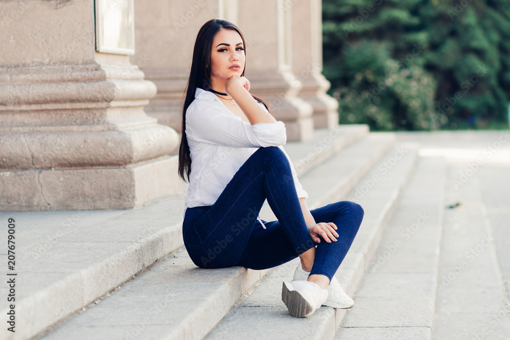 beautiful girl with long hair, fashionable girl in summer clothes, modern lifestyle, sitting on the steps on the street beautiful girl with long hair, fashionable girl in summer clothes, modern lifestyle, sitting on the steps on the street