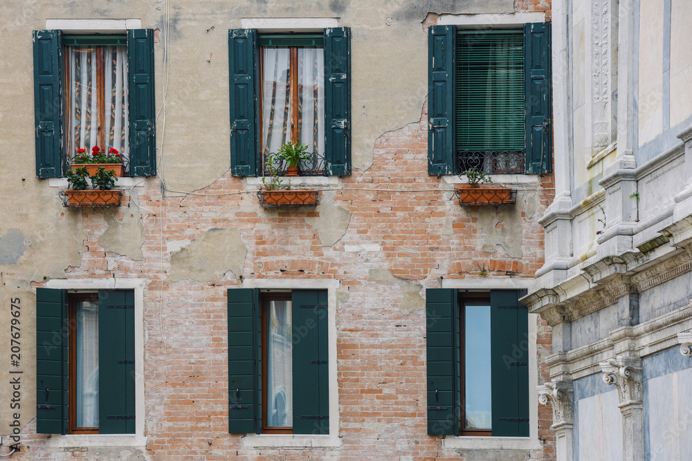 Tradional windows and balconies of an old building in Venice, Italy