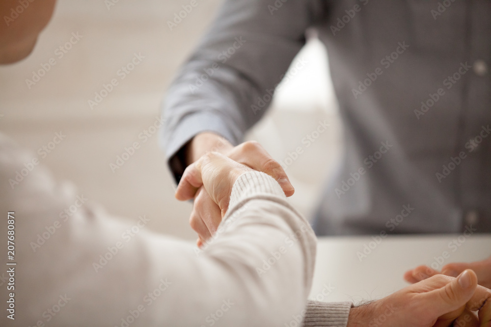 Close up of colleagues greeting with handshake, workers get acquainted at company briefing, worker shaking hand of associate congratulating, business partners closing deal. Cooperation, HR concept