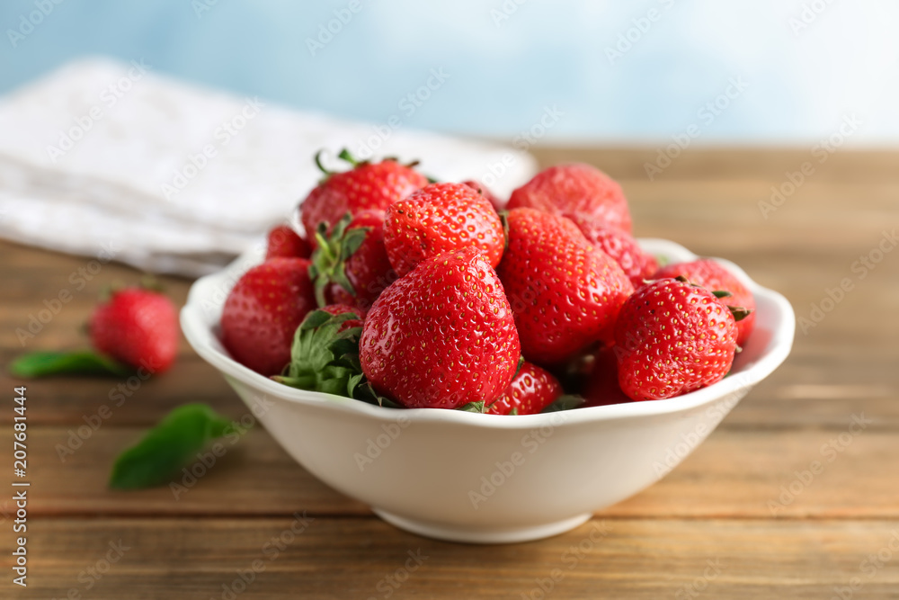 Bowl with ripe red strawberries on wooden table Bowl with ripe red strawberries on wooden table