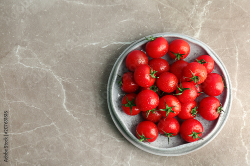 Plates with fresh ripe tomatoes on grey background, top view