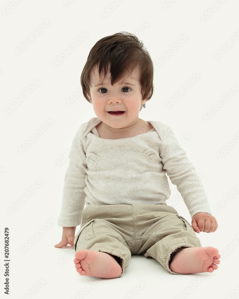 Funny baby sitting on the floor, isolated over white Funny baby sitting on the floor, isolated over white