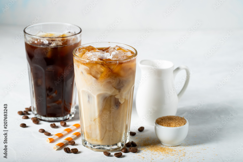 Ice coffee in a tall glass with cream poured over and coffee beans. Cold summer drink on a light blue background Ice coffee in a tall glass with cream poured over and coffee beans. Cold summer drink on a light blue background