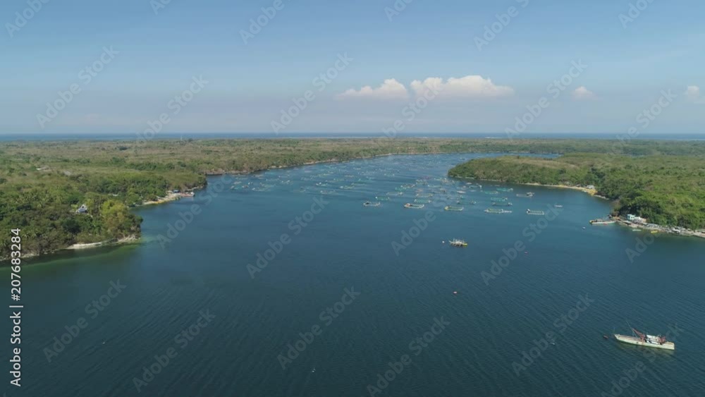 Fish farm with cages for fish and shrimp in the Philippines, Luzon. Aerial view of fish ponds for bangus, milkfish. Fish cage for tilapia, milkfish farming aquaculture or pisciculture practices. Fish farm with cages for fish and shrimp in the Philippines, Luzon. Aerial view of fish ponds for bangus, milkfish. Fish cage for tilapia, milkfish farming aquaculture or pisciculture practices.