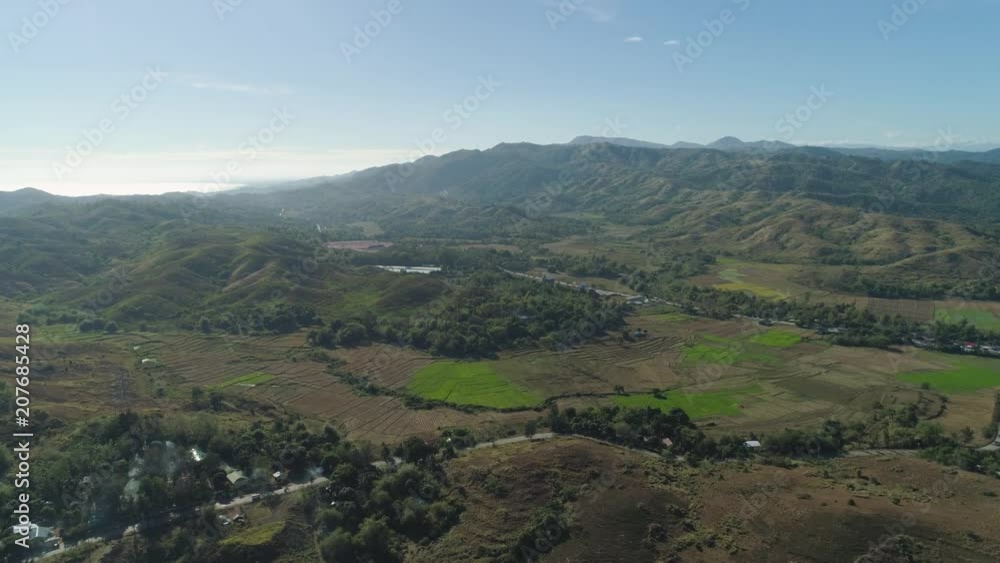 Mountain valley with village, farmland in the Philippines, Luzon. Aerial view: Mountain valley with green trees and river. Mountain valley with village, farmland in the Philippines, Luzon. Aerial view: Mountain valley with green trees and river.