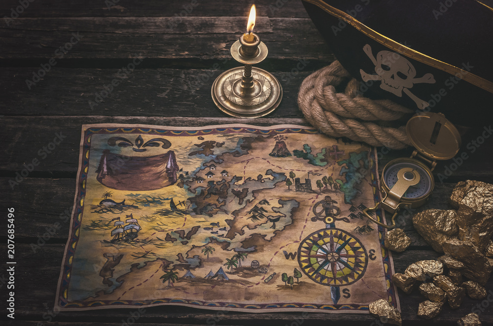 Naklejka premium Piracka skarb mapa, złociste bryłki i pirata kapelusz na starzejącym się drewnianym stołowym tle. Podróże morskie.