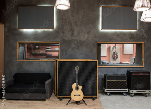 Acoustic guitar against amplifier in recording studio photo