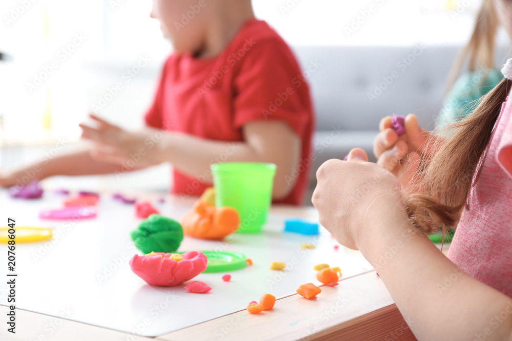 Cute little children using play dough at table, closeup Cute little children using play dough at table, closeup
