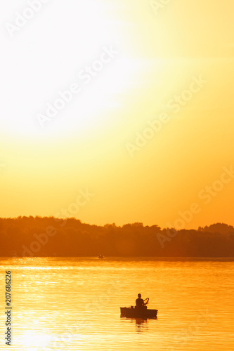 Silhouette of fisherman during sunset