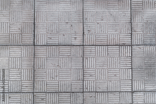 Texture of square tiles in gray with perpendicular strips.