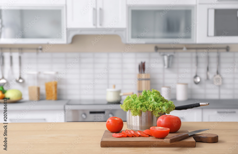 Fresh vegetables and blurred view of kitchen interior on background Fresh vegetables and blurred view of kitchen interior on background
