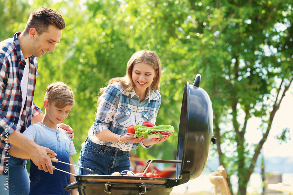 Happy family having barbecue outdoors Stock-foto | Adobe Stock