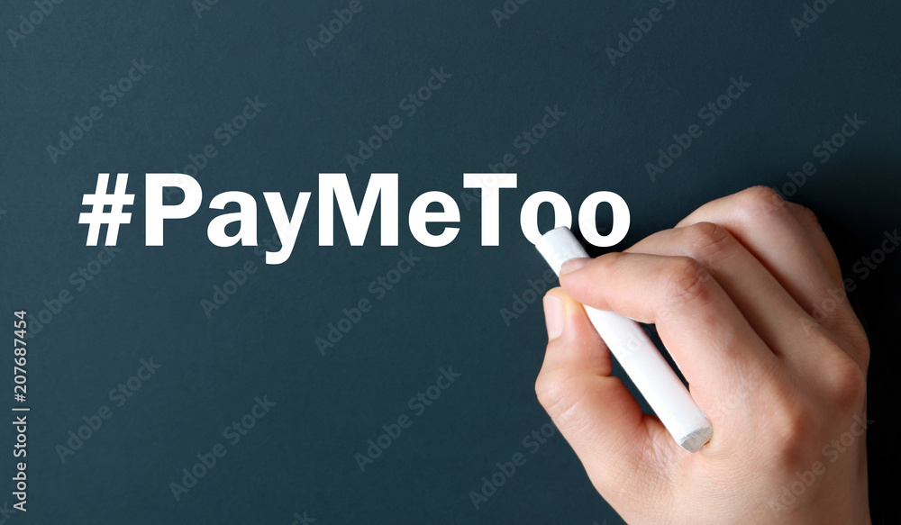 The hand writing text #PayMeToo in white chalk. #PAYMETOO as a new movement The hand writing text #PayMeToo in white chalk. #PAYMETOO as a new movement