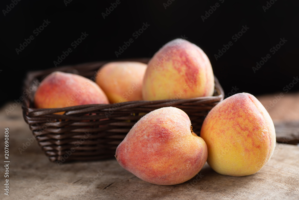 Ripe peaches in a basket on wooden, tropical fruit Ripe peaches in a basket on wooden, tropical fruit
