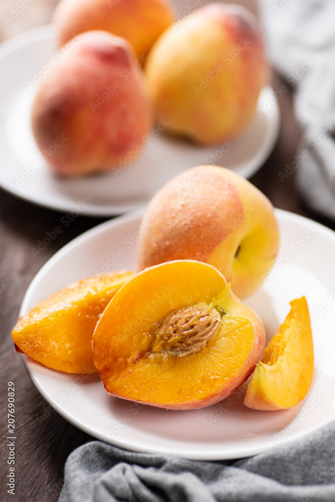 Ripe peaches on white dish, tropical fruit