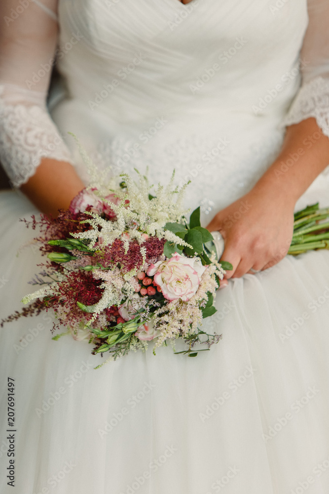 Bride holding her bouquet in her lap during her wedding Bride holding her bouquet in her lap during her wedding